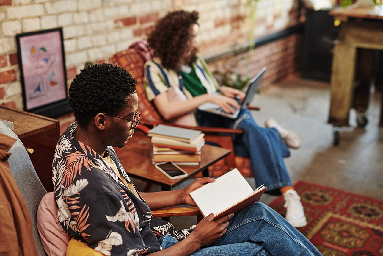 Young man reading book while sitting