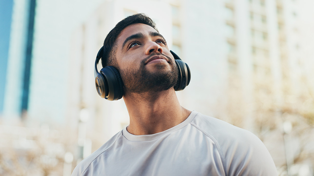 Man with headphones listening to music, looking up