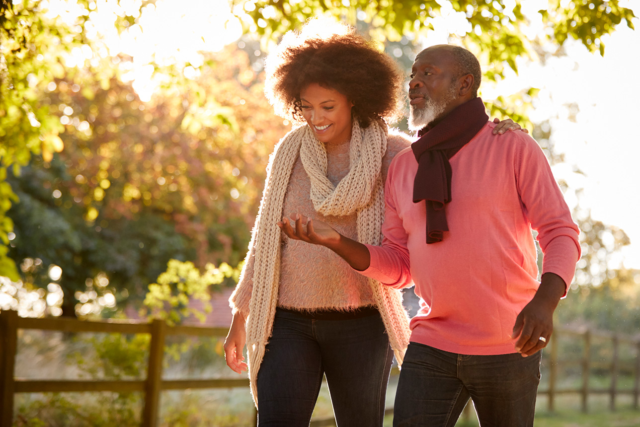 Senior father with adult daughter enjoying autumn walk