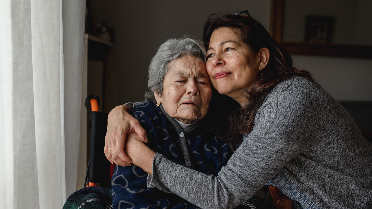 Mother in wheelchair and daughter hugging