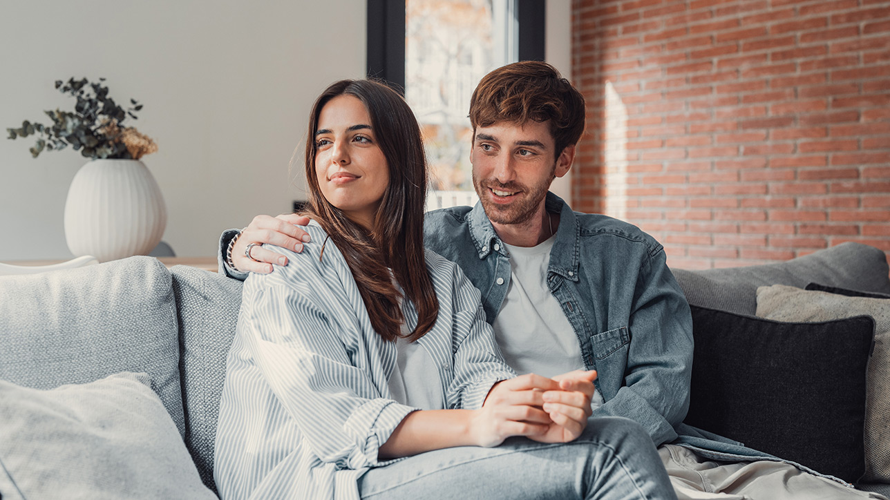 A young couple relaxes on couch together while listening