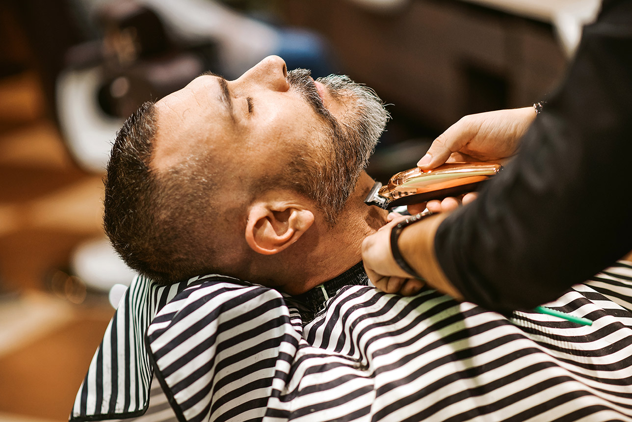 Barber trims the beard of a customer
