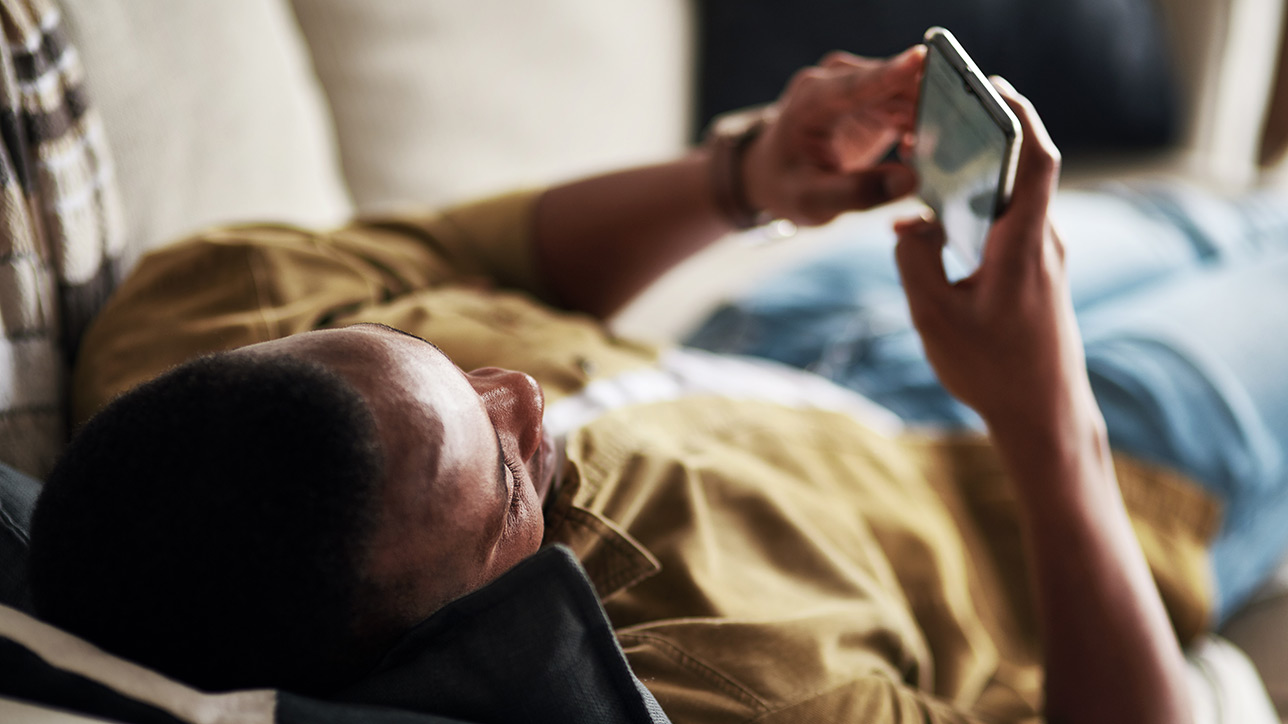 Man on couch using phone