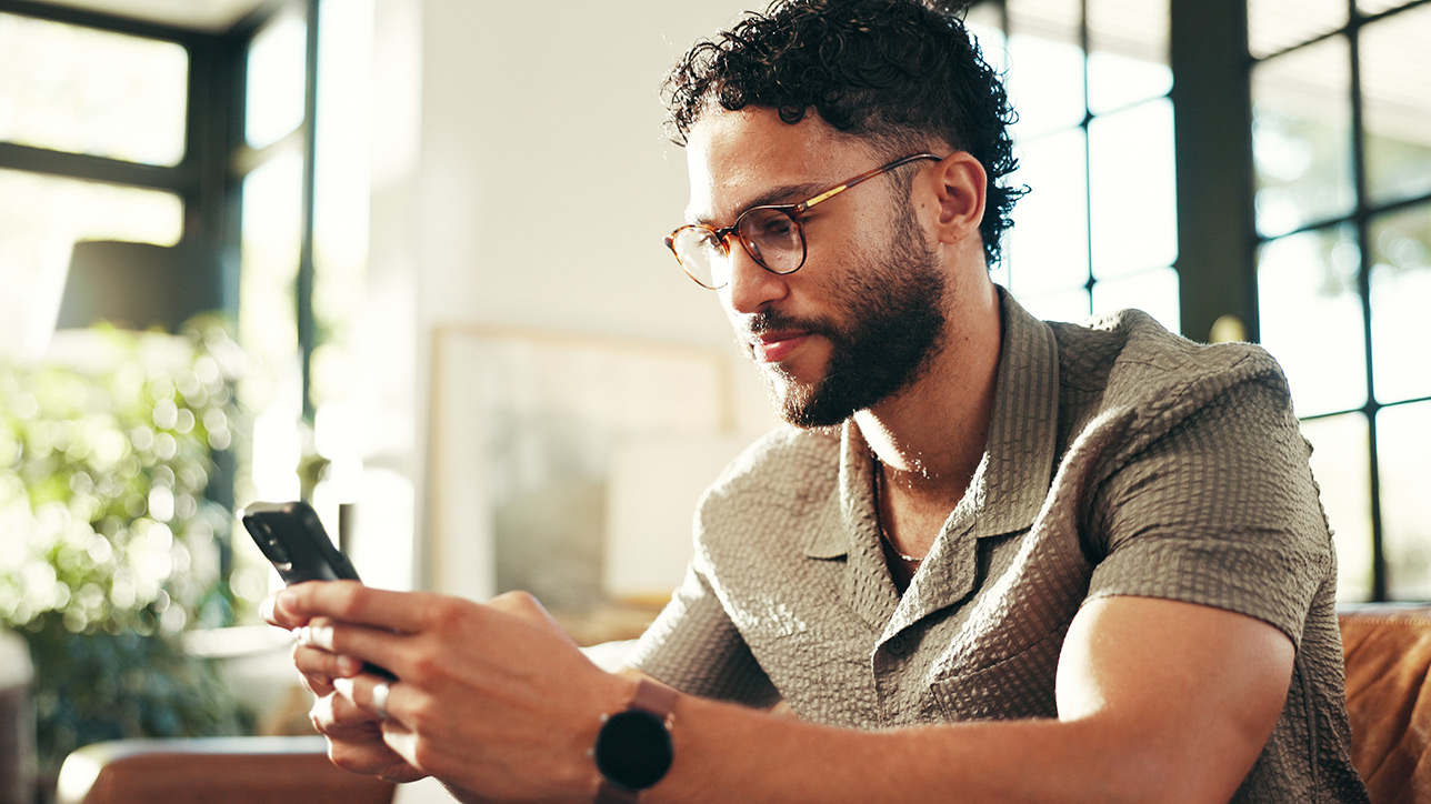Man on sofa looking at smartphone