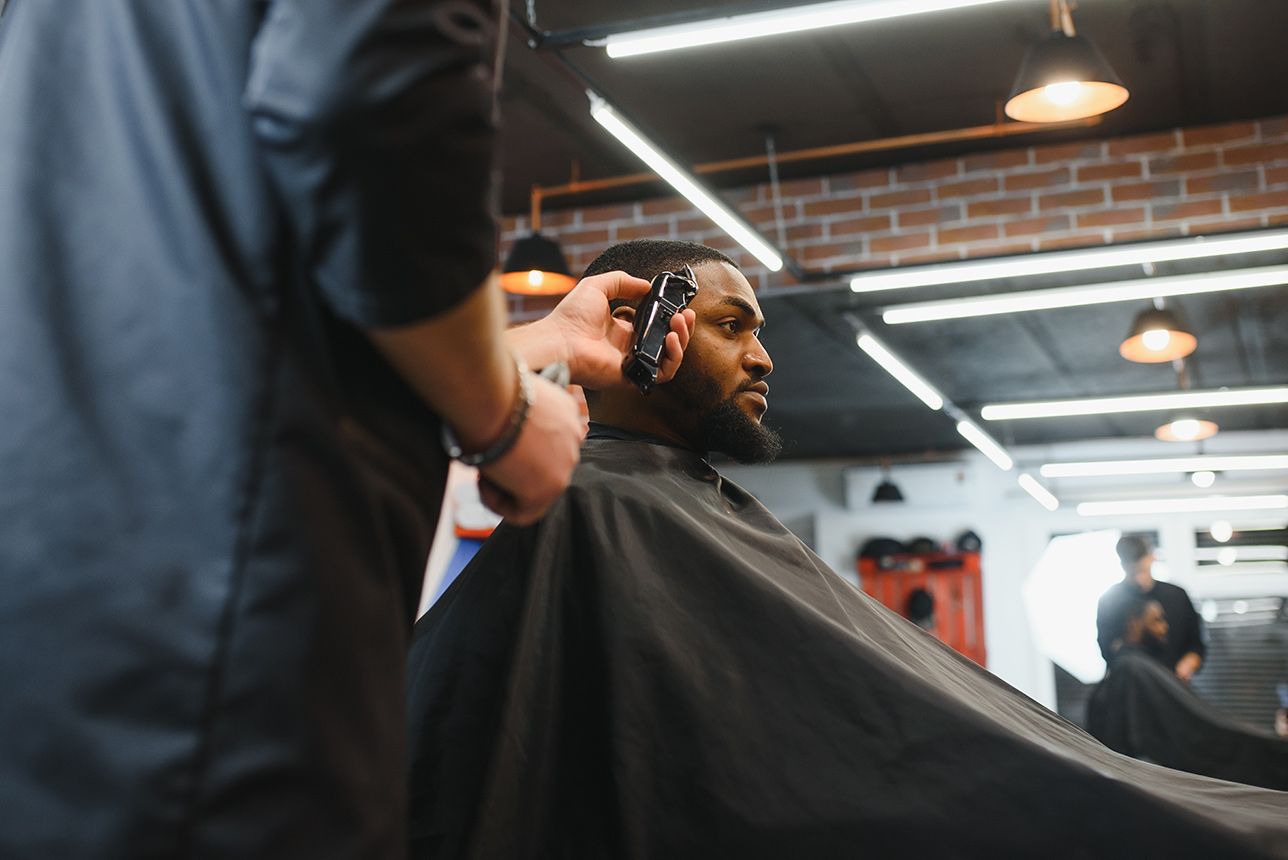 Young Black man getting a haircut at a barbershop